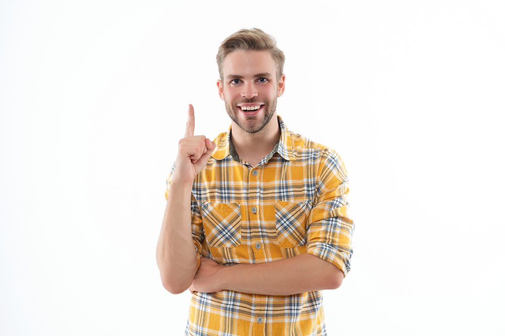 young man smiling pointing finger up concept of skin resurfacing